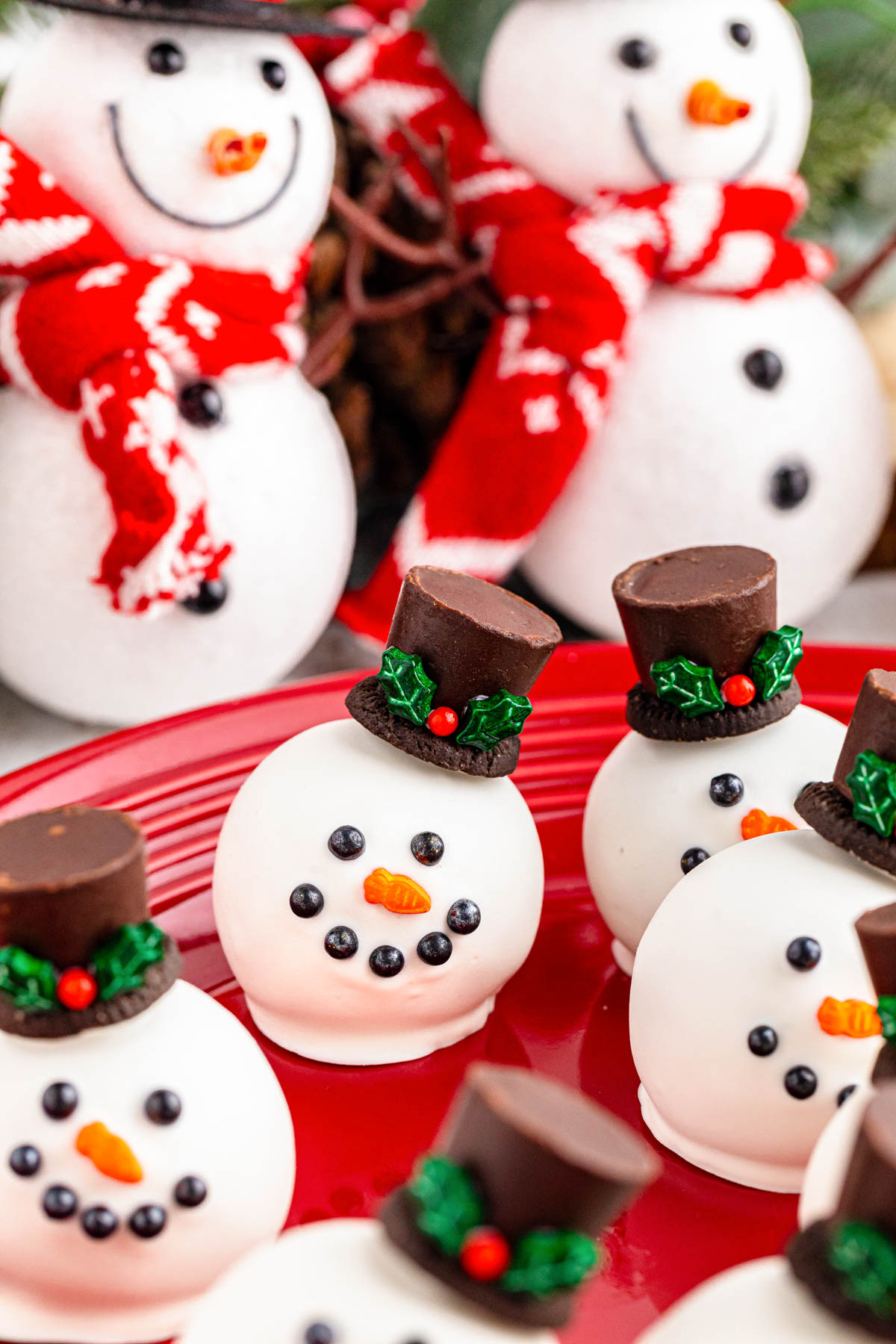 Close up of snowmen oreo balls on a red plate.