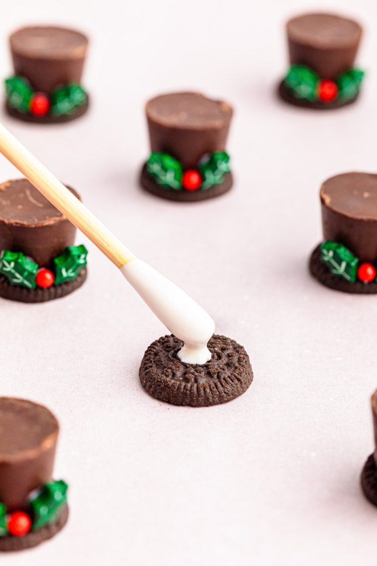 Melted white chocolate being added to a mini oreo.