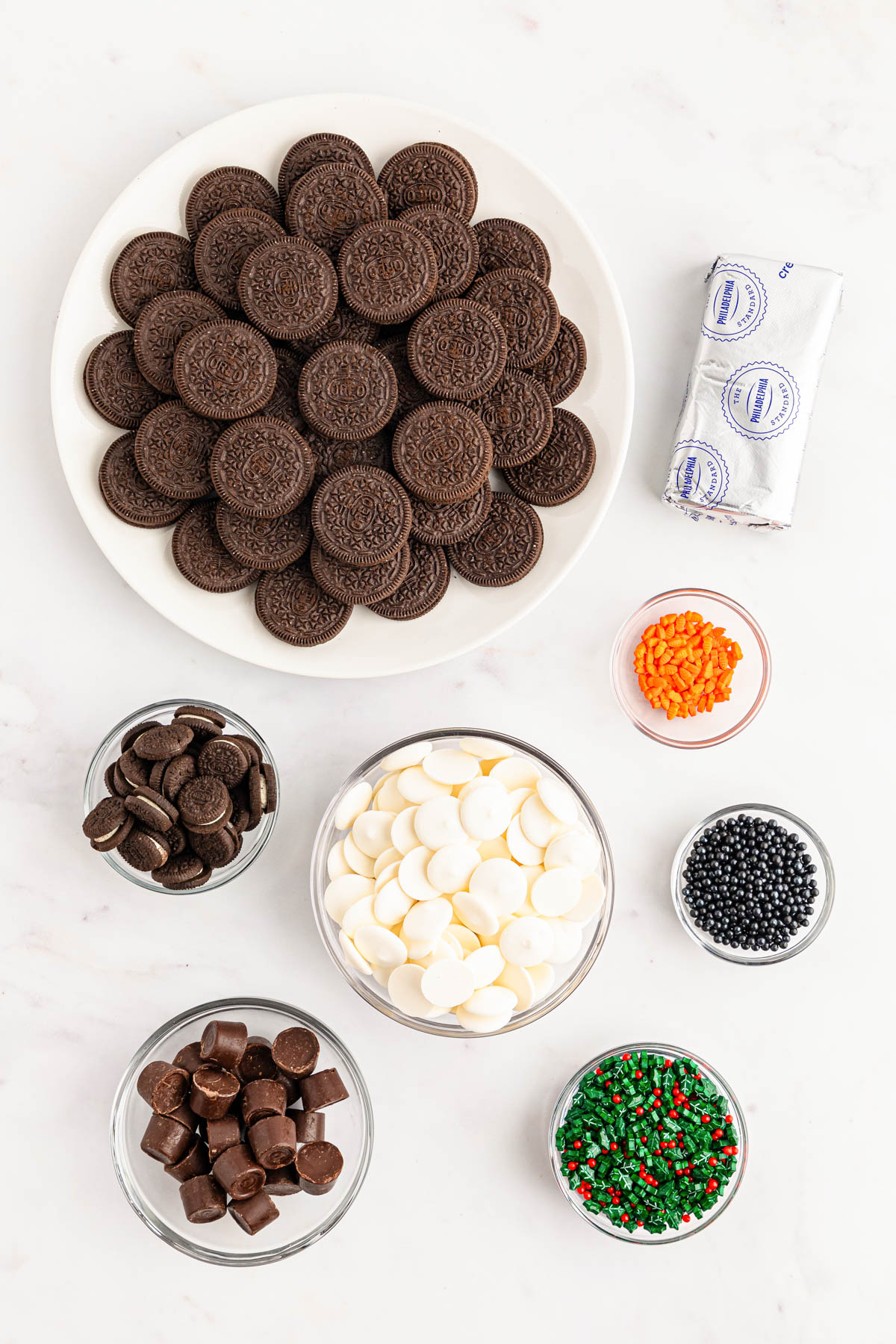 Ingredients to make Snowman Oreo Balls on a white table.