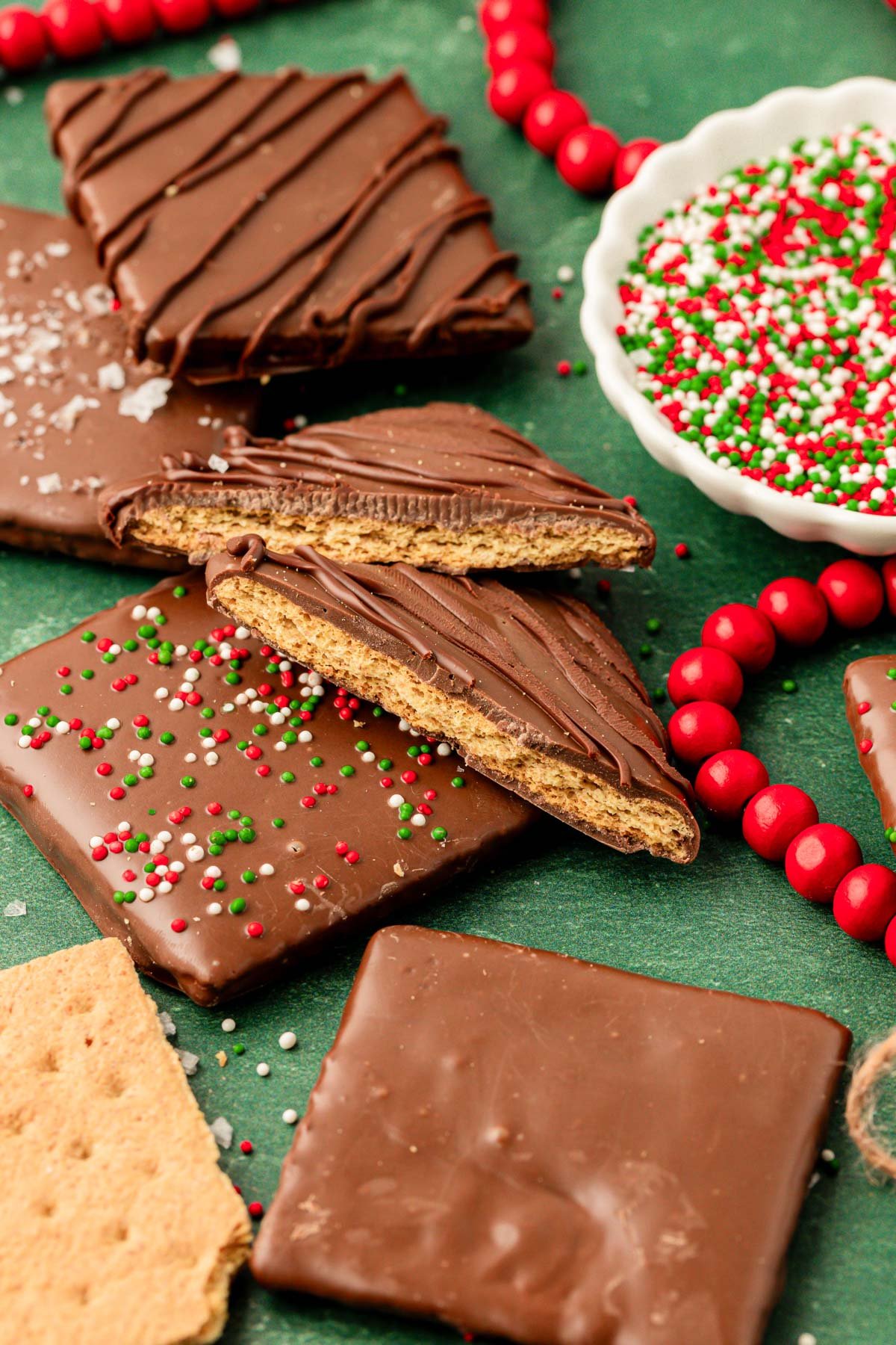 Close up of chocolate covered graham crackers for the holidays on a green counter.