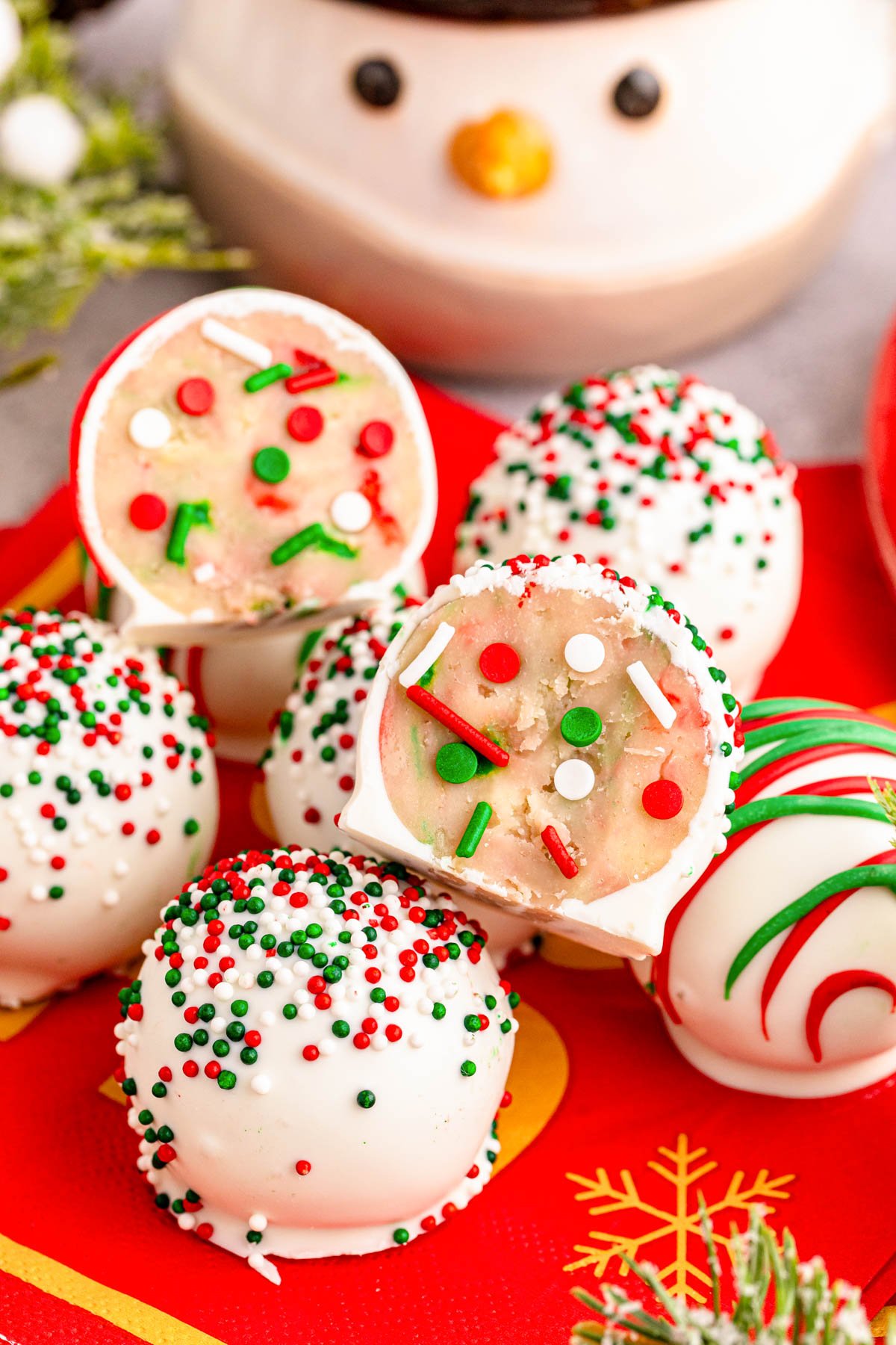 Close up photo of christmas cookie truffles on a plate, One split in half to show the inside.