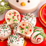 Sugar Cookie truffles on a red plate, one split in half to show inside.