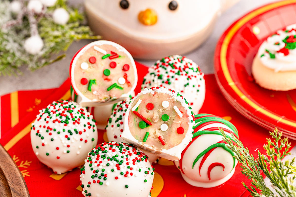 Sugar Cookie truffles on a red plate, one split in half to show inside.