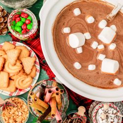 Overhead photo of a crockpot of hot chocolate with ingredients to add to it.