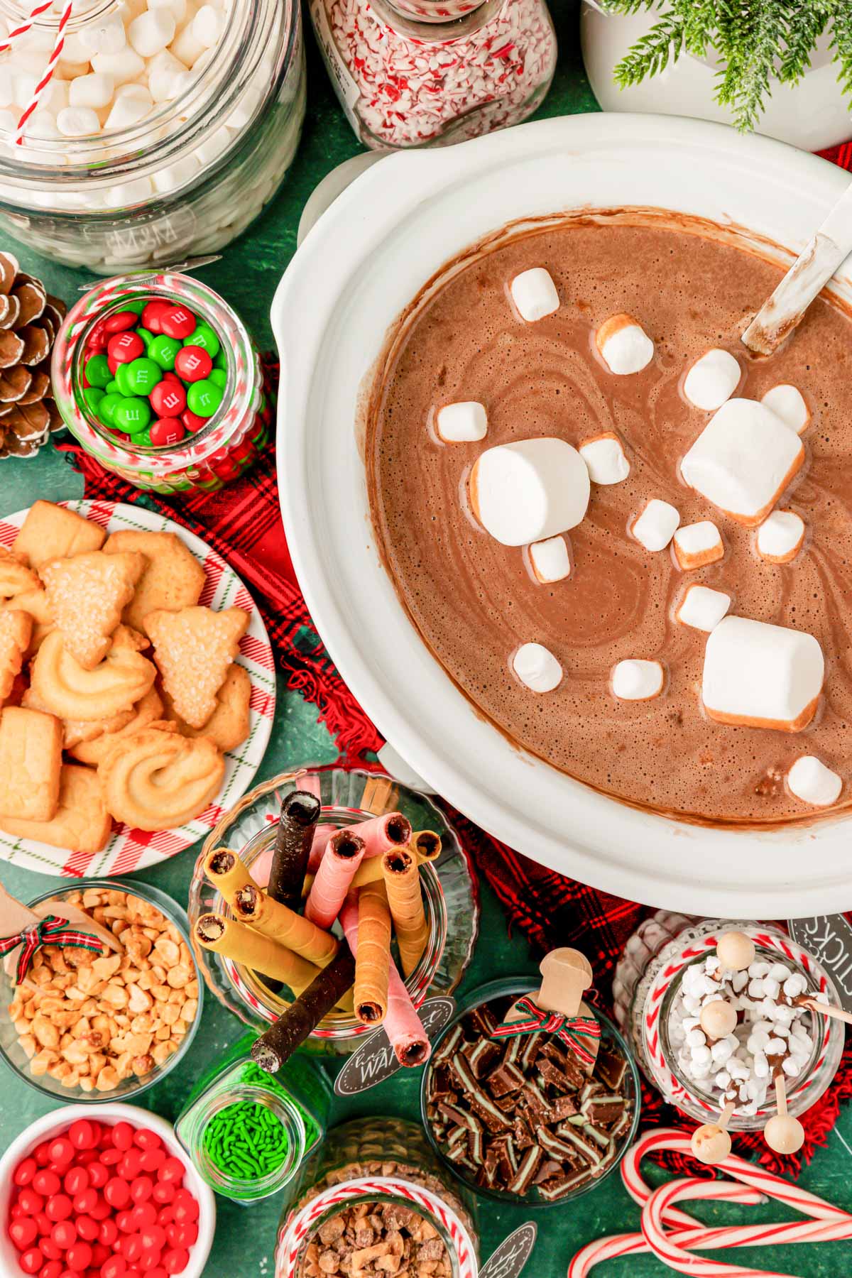 Overhead photo of a crockpot of hot chocolate with ingredients to add to it.