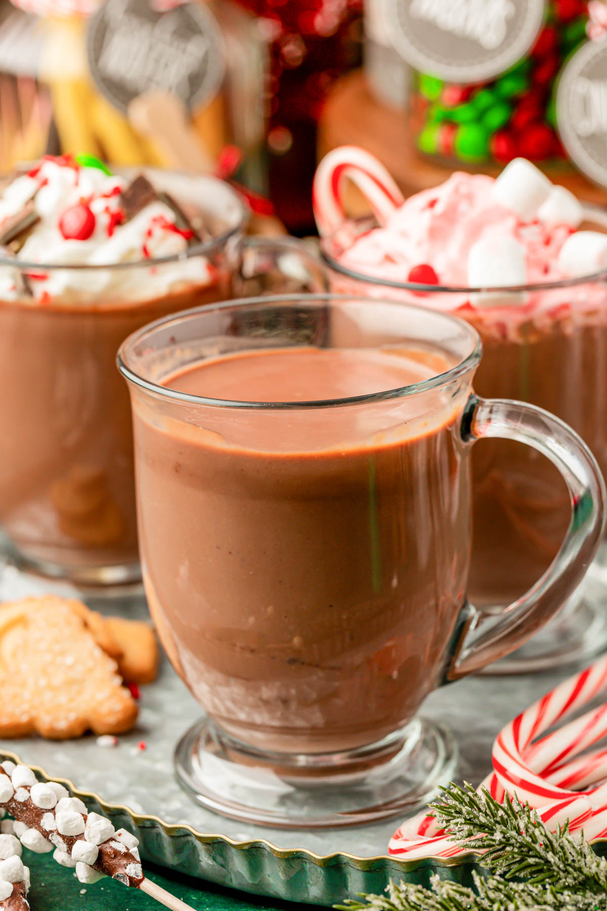 A mug of hot chocolate with more mugs behind it.