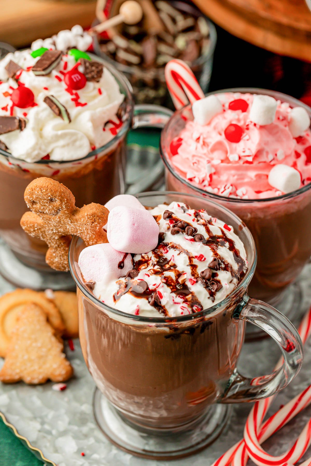 Three glass mugs of hot chocolate on a table.