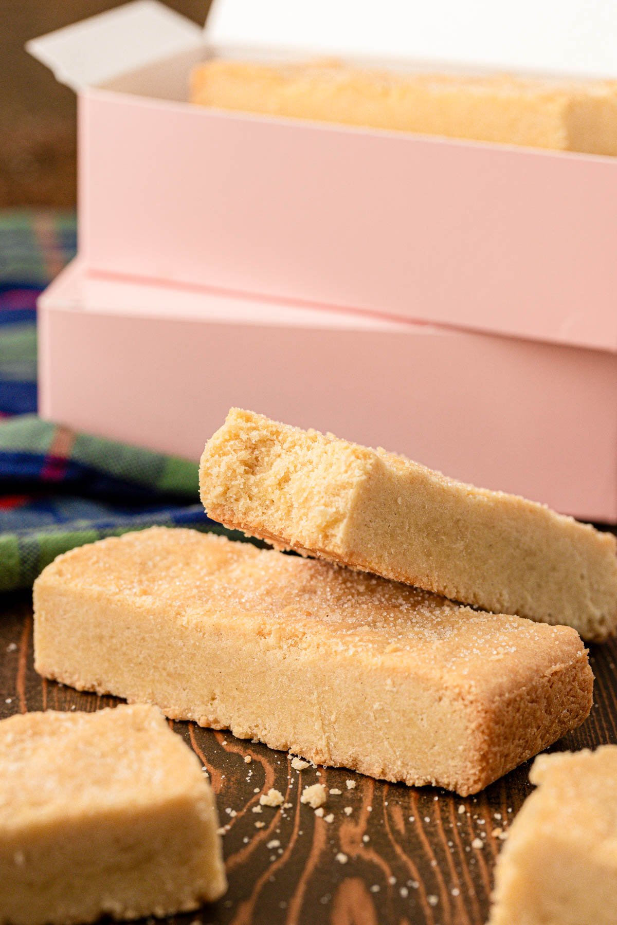 Ted lasso Shortbread Biscuits on a wooden table with pink boxes in the background.