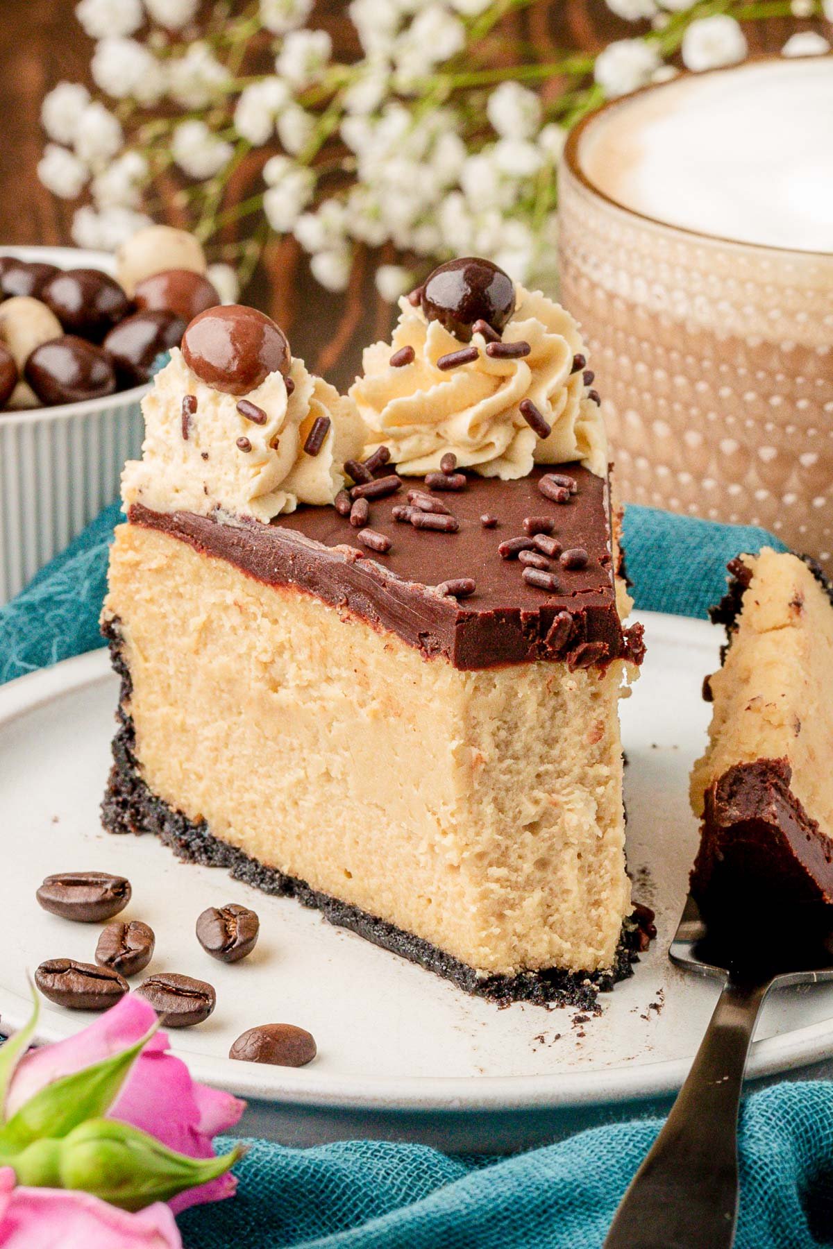 A slice of coffee cheesecake on a white plate with a bite missing.