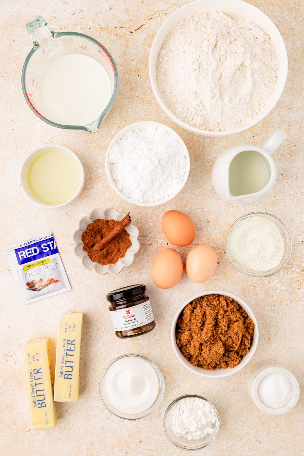 Ingredients to make overnight cinnamon rolls on a tan table.