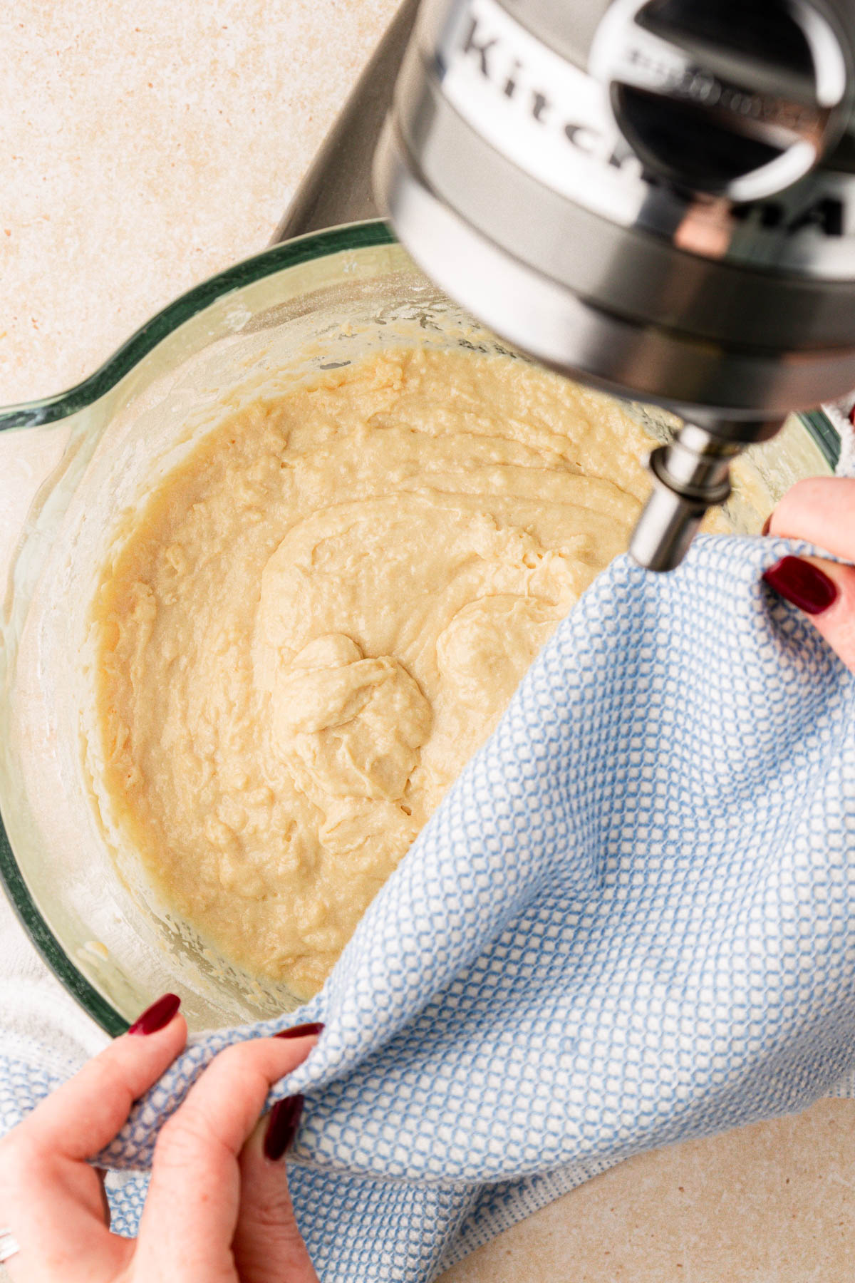 Dough in a mixing bowl being covered with a cloth.