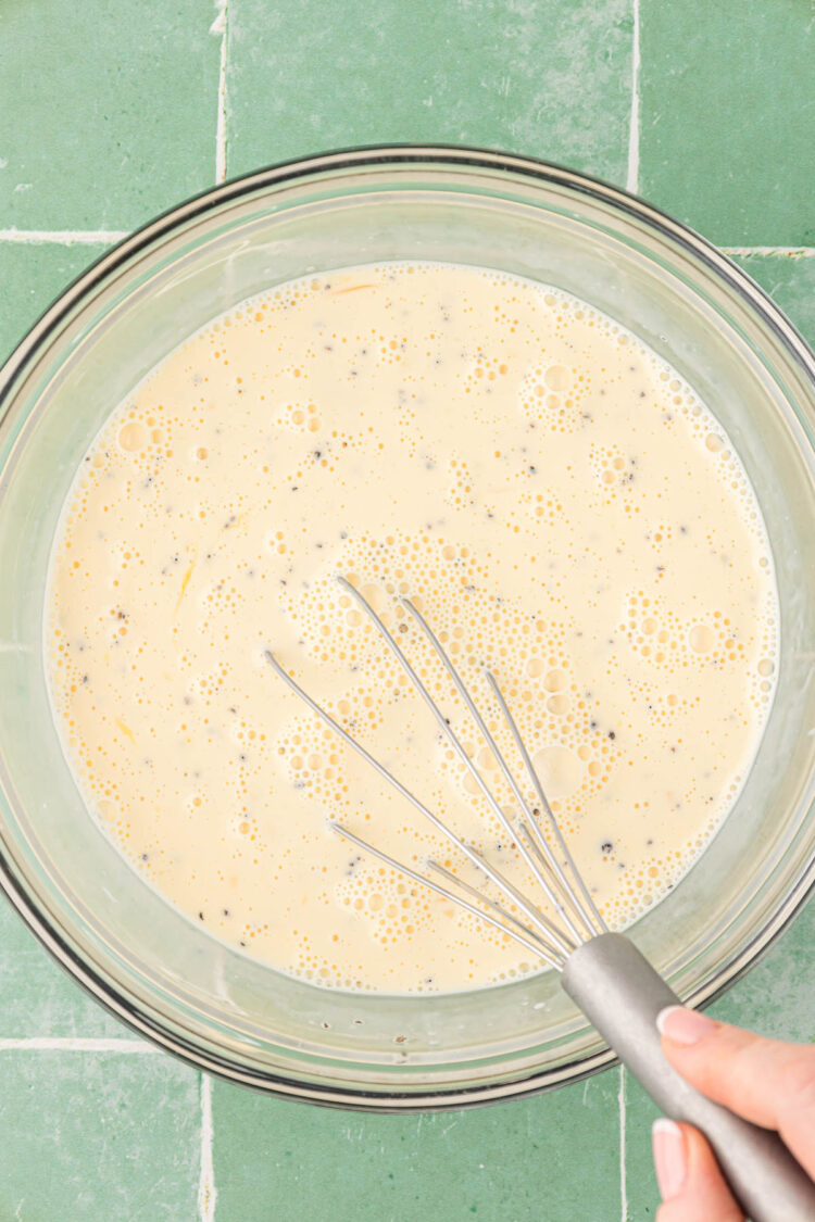 Eggs, cream, and spices mixed together in a bowl.