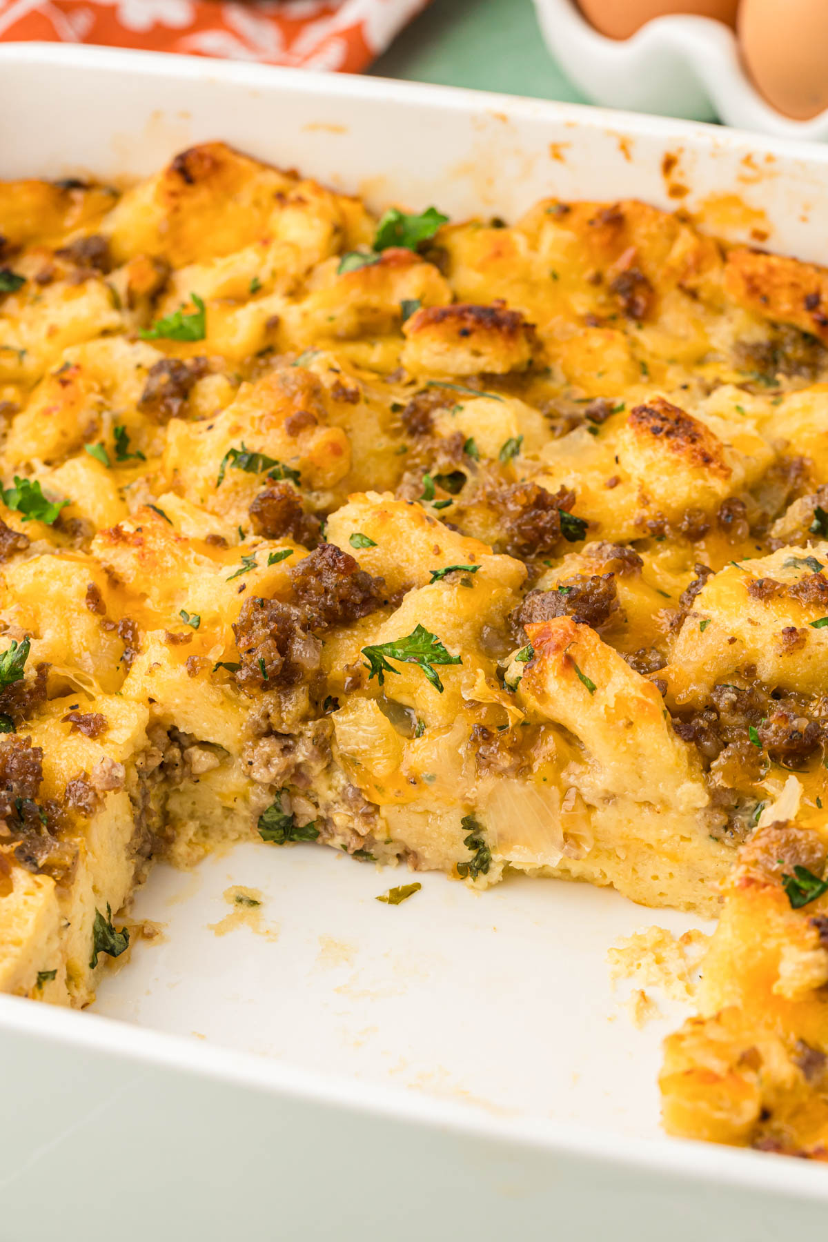 Breakfast strata in a baking pan with a slice missing.