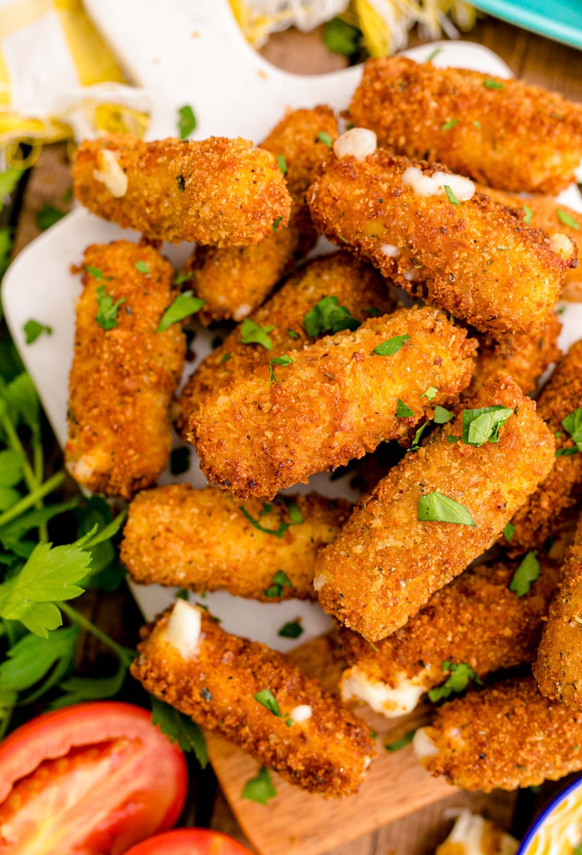 Mozzarella sticks piled on a serving board.