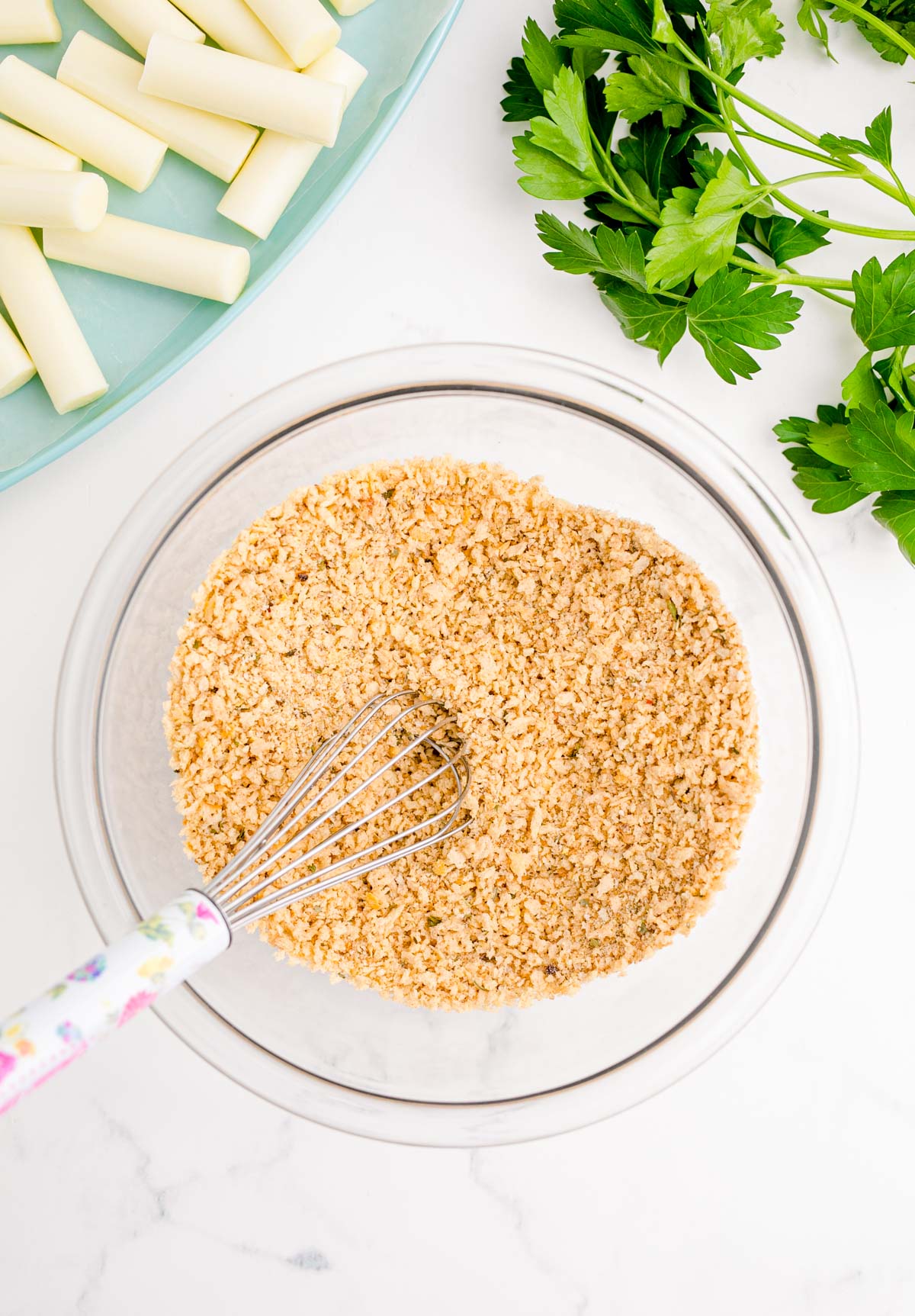 Breadcrumbs being mixed together in a bowl.