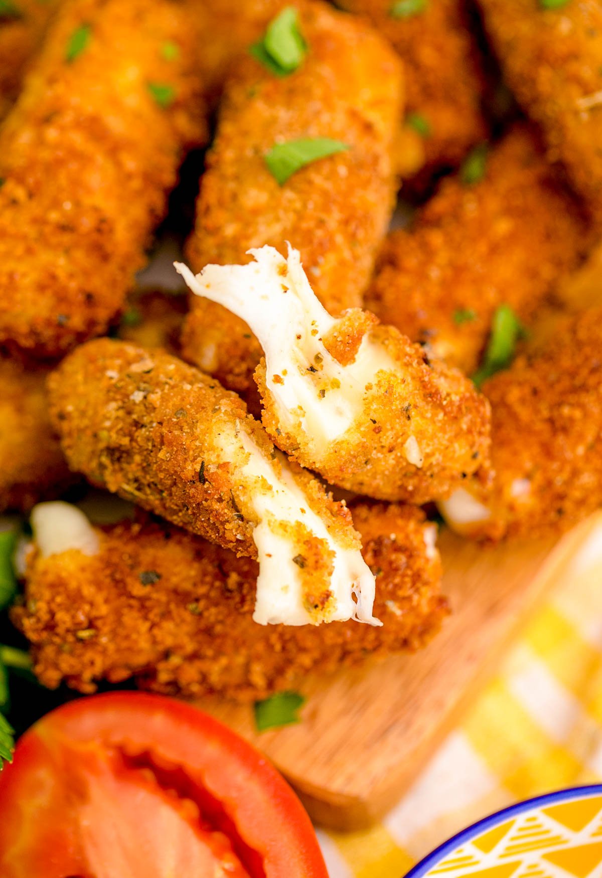 Mozzarella sticks on a wooden board.