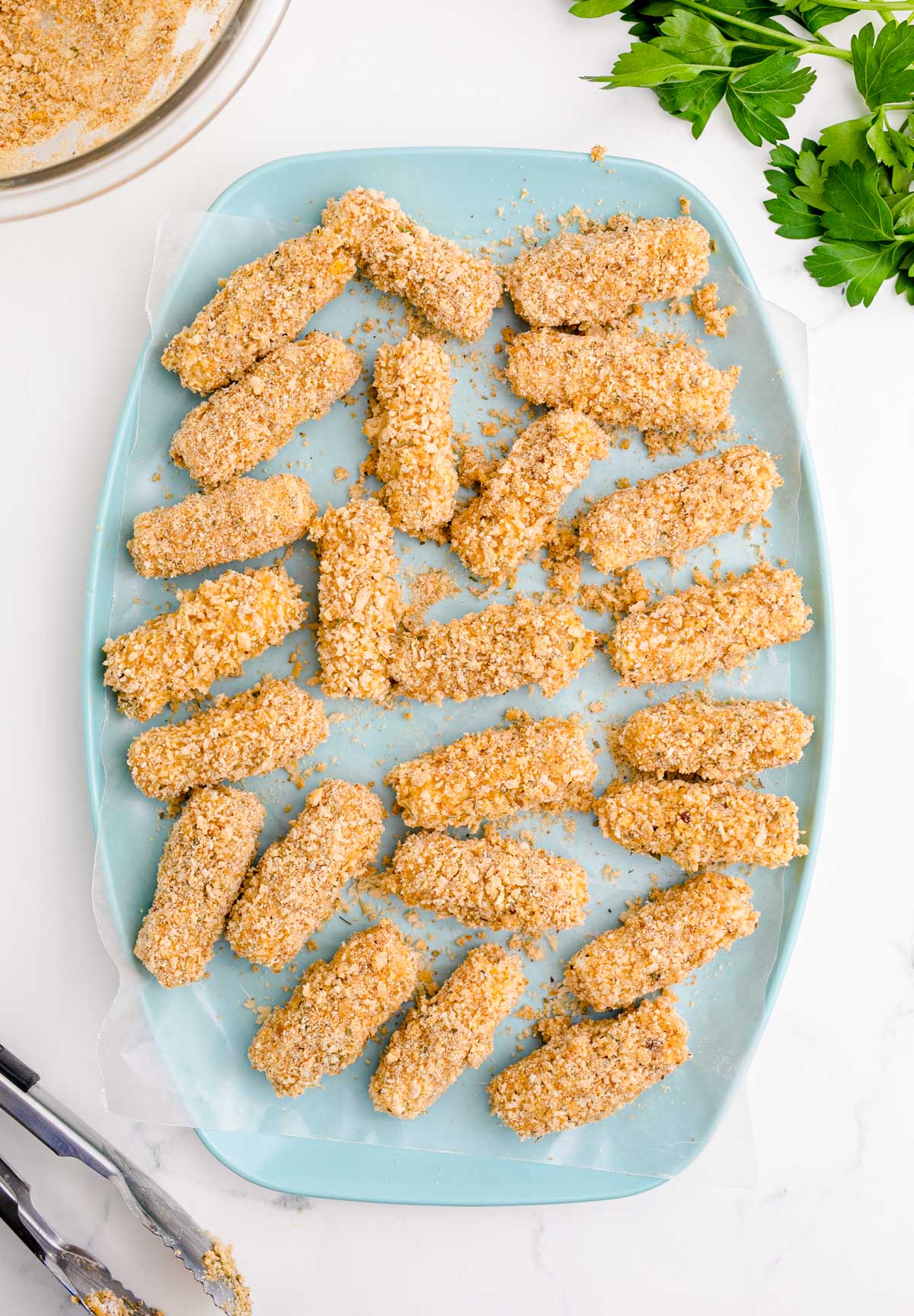 Overhead photo of mozzarella sticks on a blue plate.