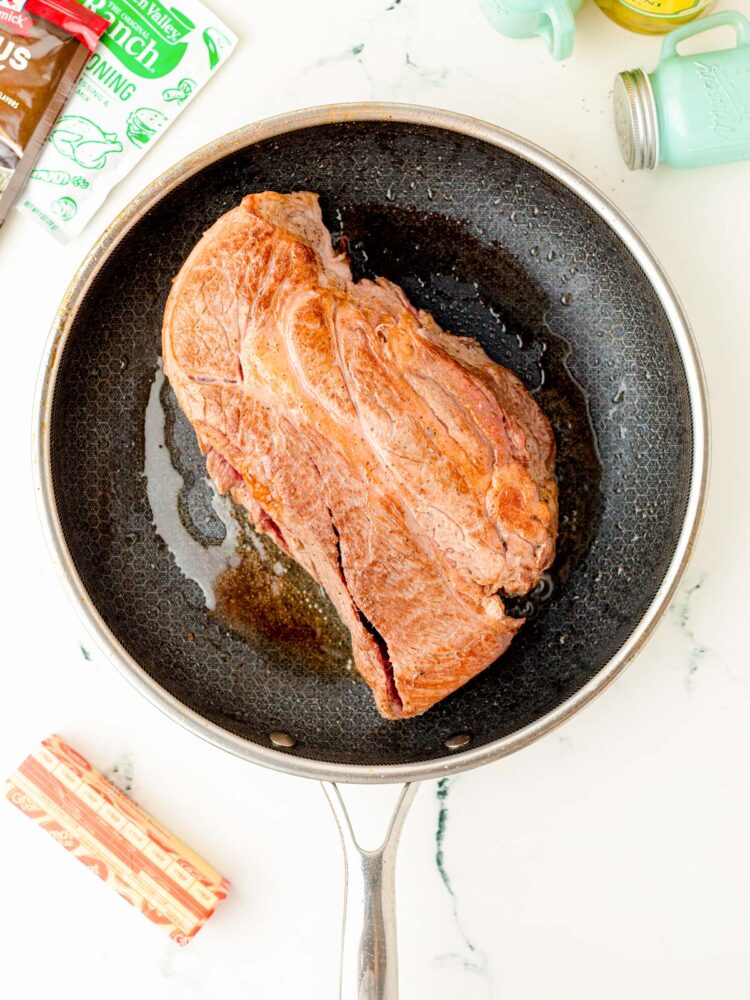 Beef Roast being seared in skillet.