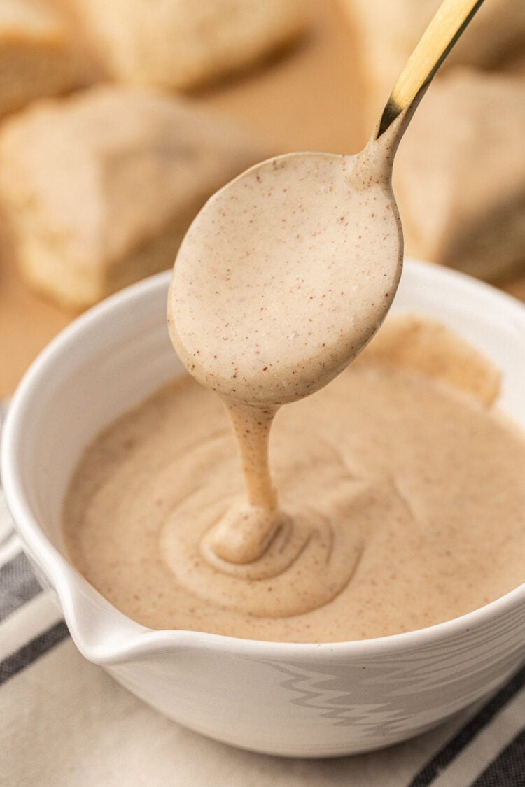 Icing for vanilla scones in a bowl with a spoon.