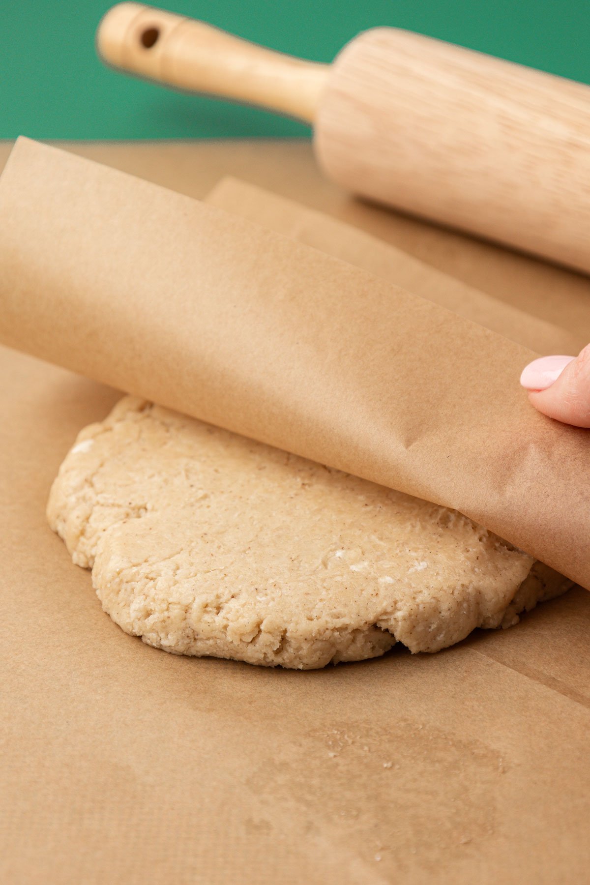 Dough that has been rolled out under parchment paper.