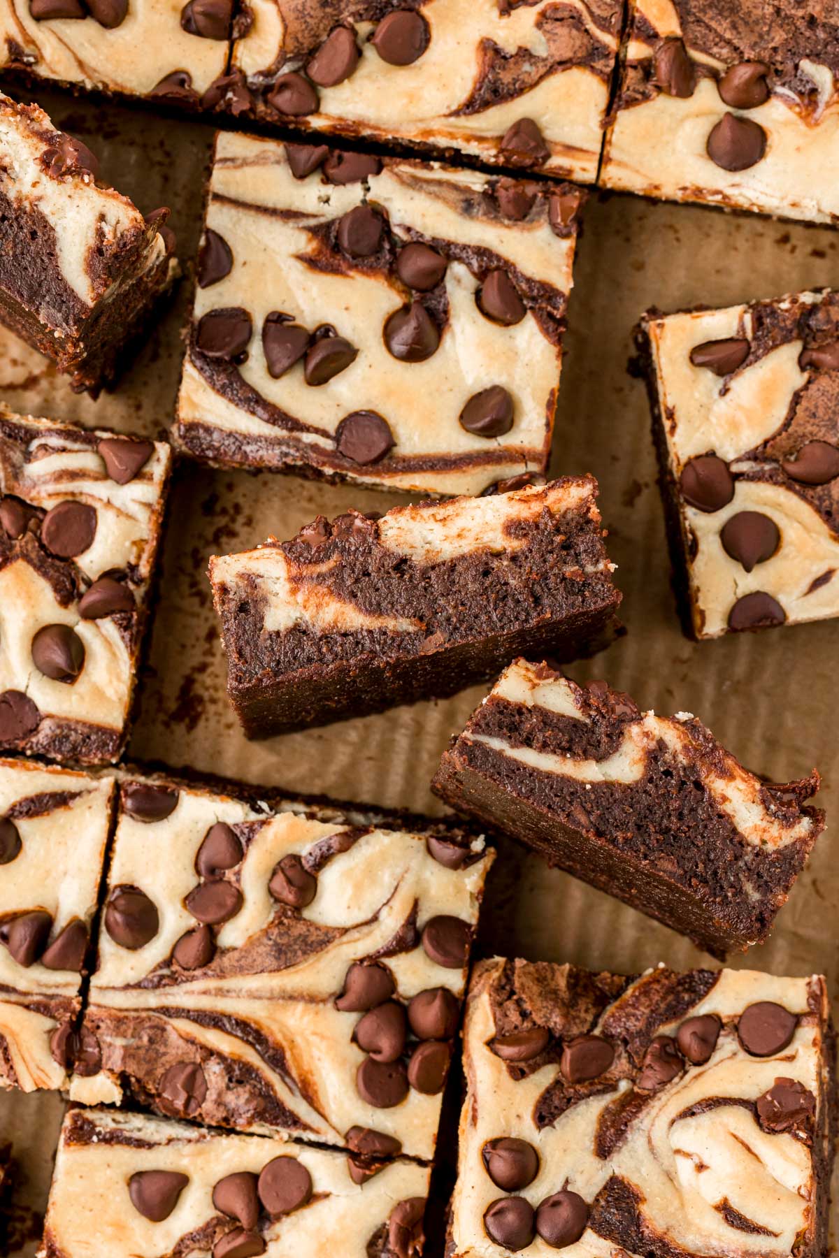 Overhead photo of brownies with cream cheese on a wooden board.