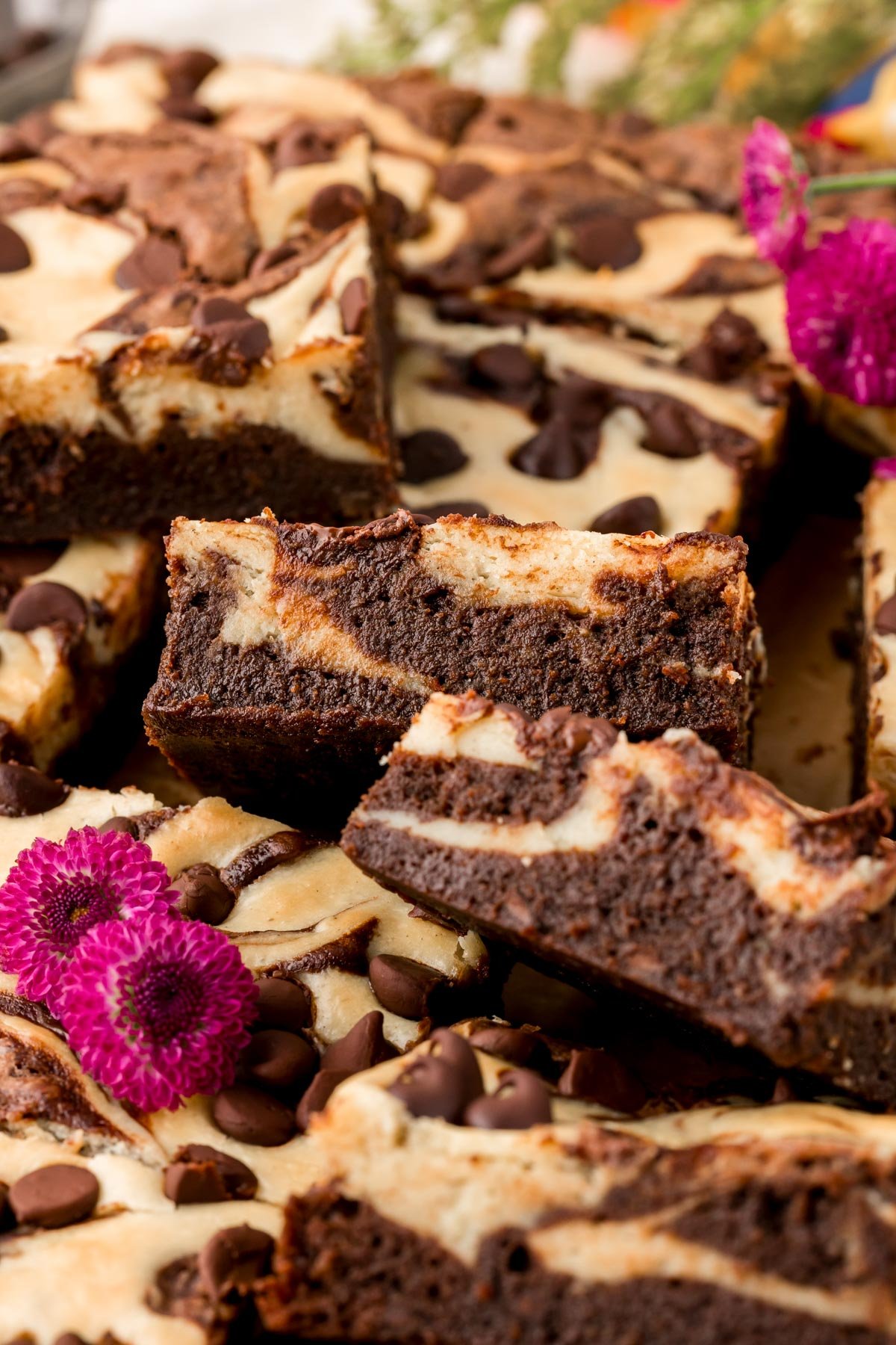 Close up of brownies with cream cheese swirl on a table.