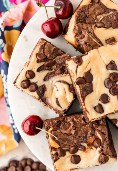 Overhead photo of cheesecake brownies on a cake stand.