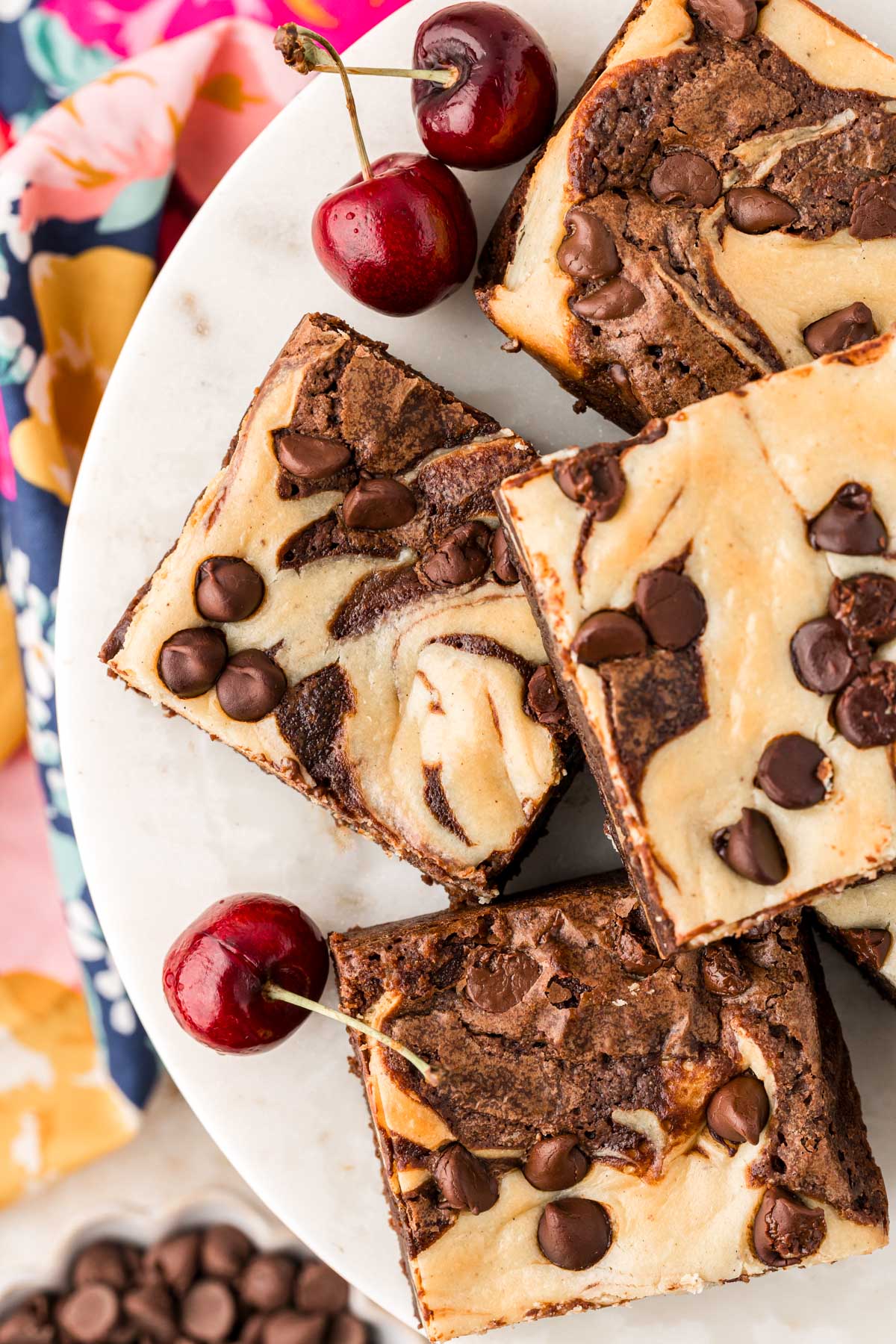 Overhead photo of cheesecake brownies on a cake stand.