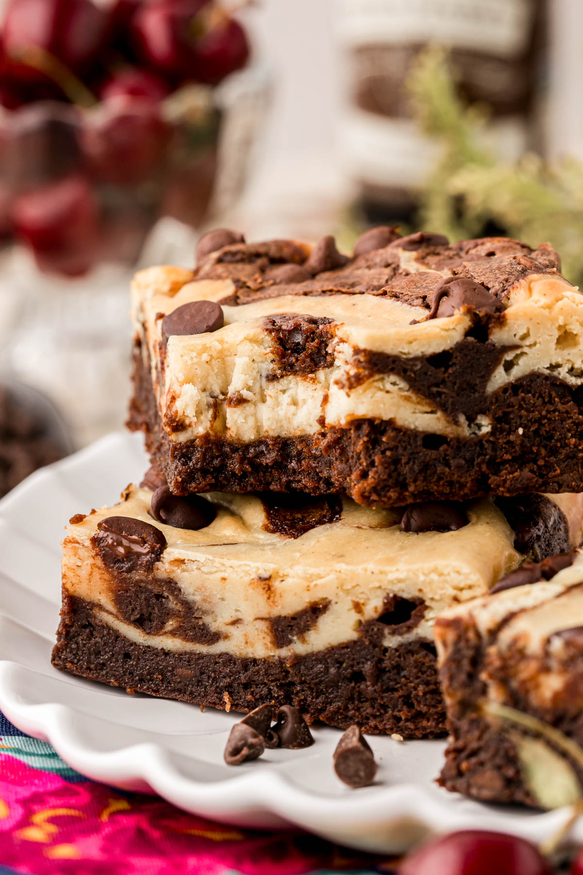 Close up of two cream cheese brownies stacked on top of each other, one is missing a bite.