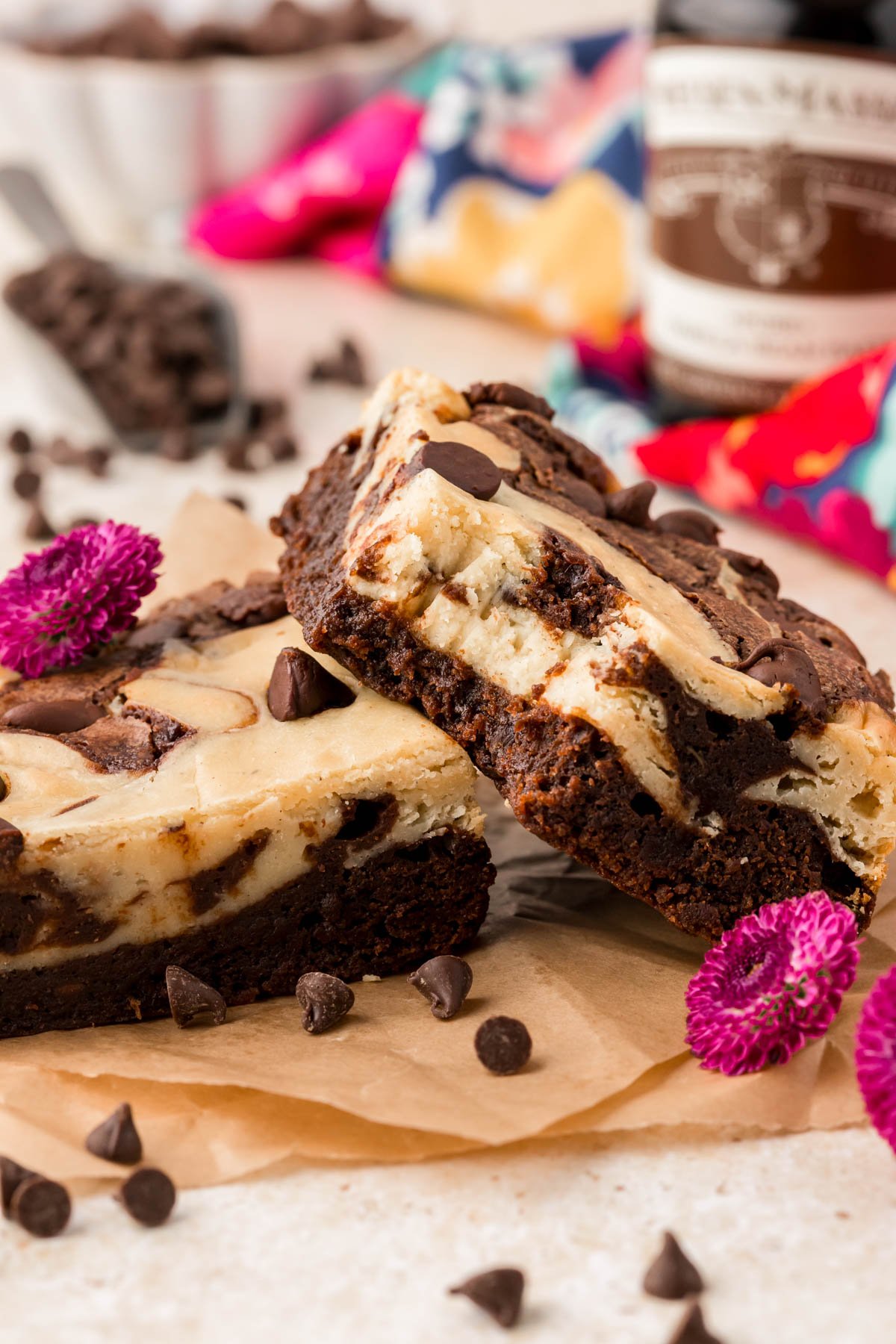 Two cream cheese brownies on a table, one is missing a bite.