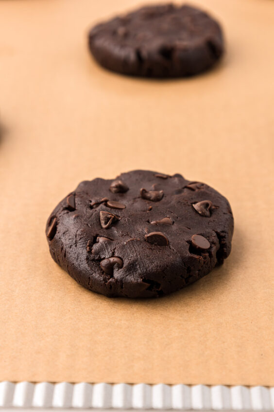 Chocolate cookies on parchment baking sheet ready to bake.