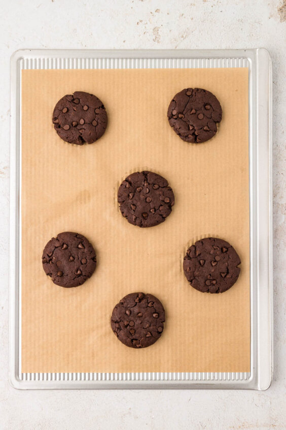 Baked chocolate cookies on a cookie sheet.