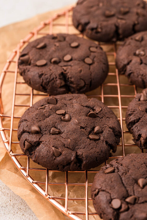 Chocolate chocolate chip cookies on a wire rack.