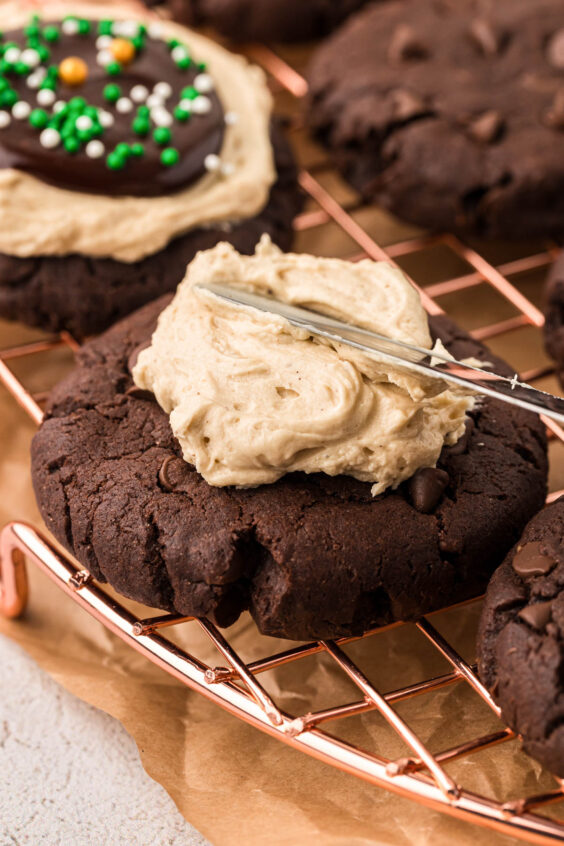 Irish cream frosting being added to chocolate cookies.