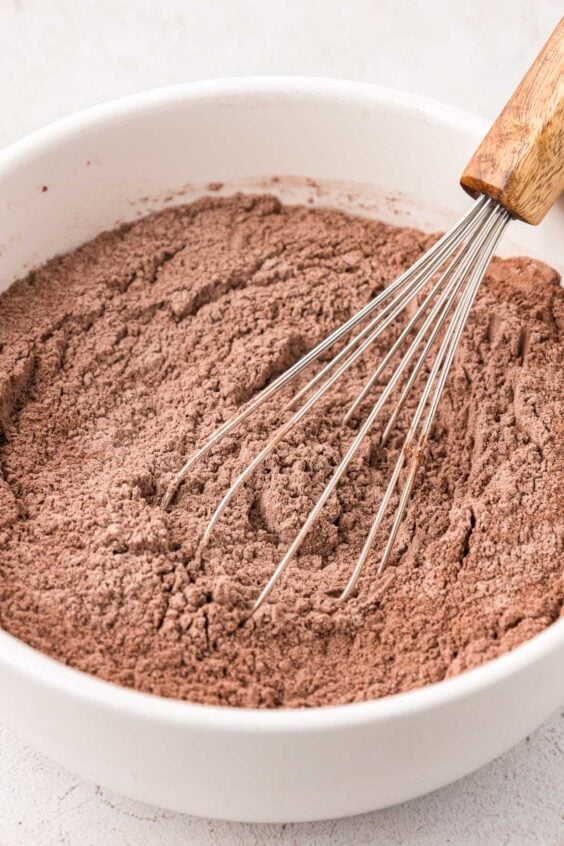 Dry ingredients for chocolate cookies being whisked in a bowl.