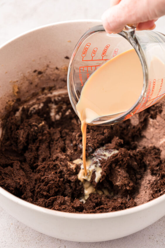 Irish cream being poured into chocolate cookie dough.