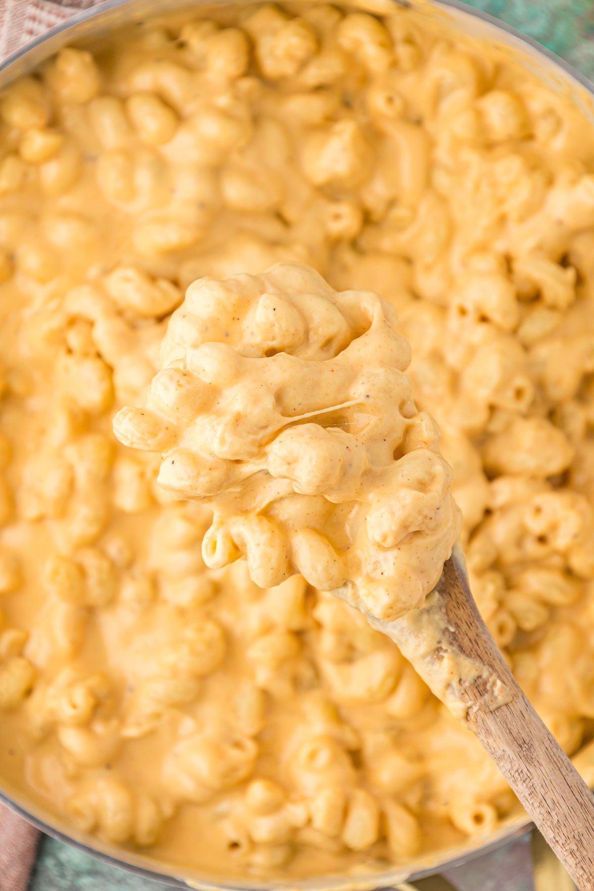 Overhead photo of creamy mac and cheese being spooned out of a skillet. 