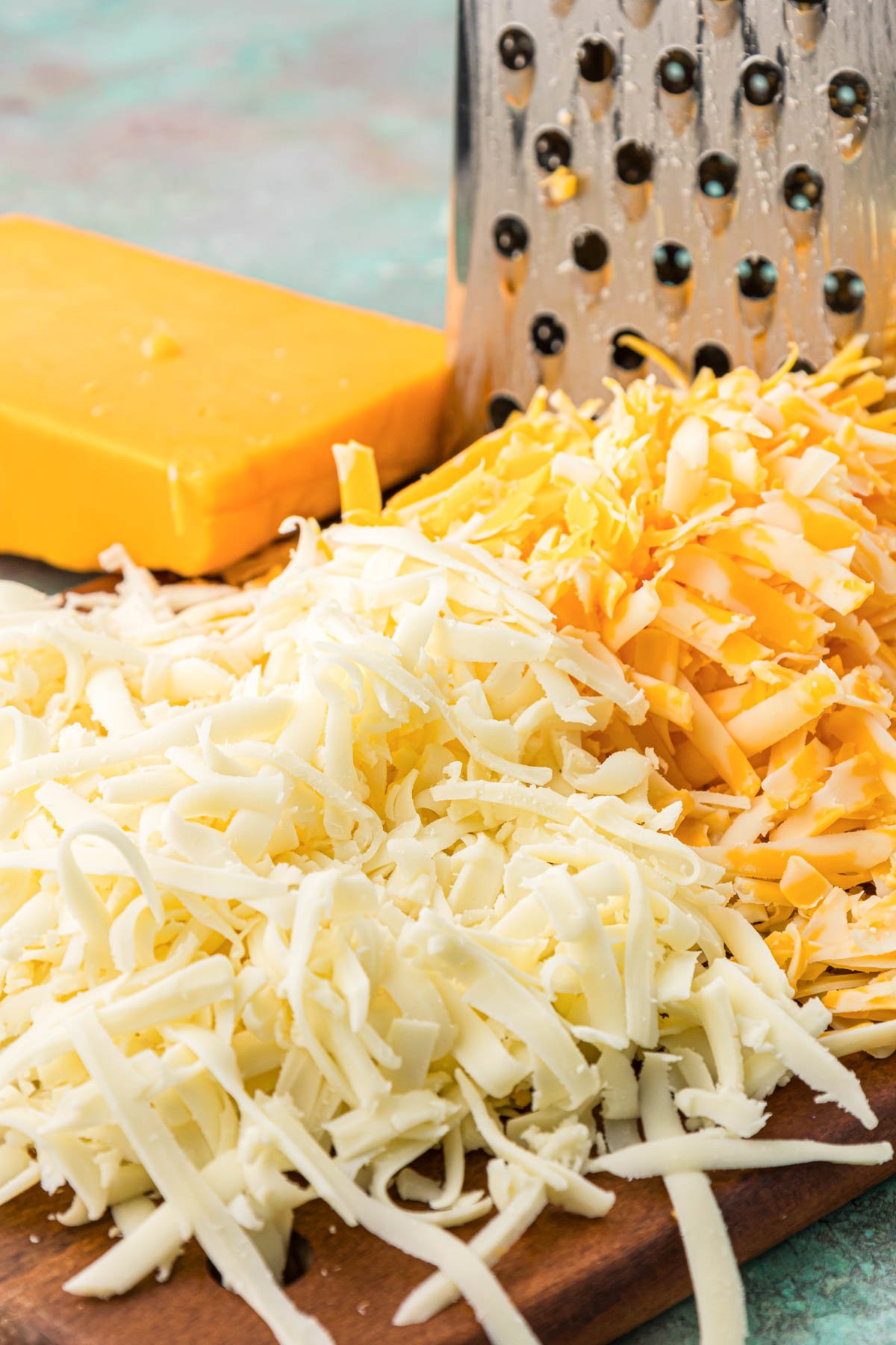 Fresh shredded cheese on a wooden board.