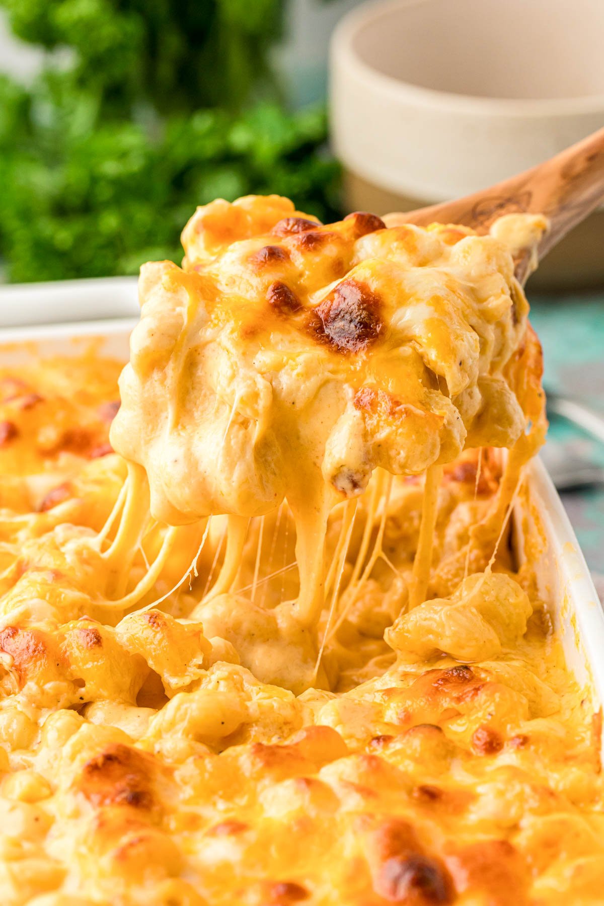 Mac and cheese being scooped out of a pan.