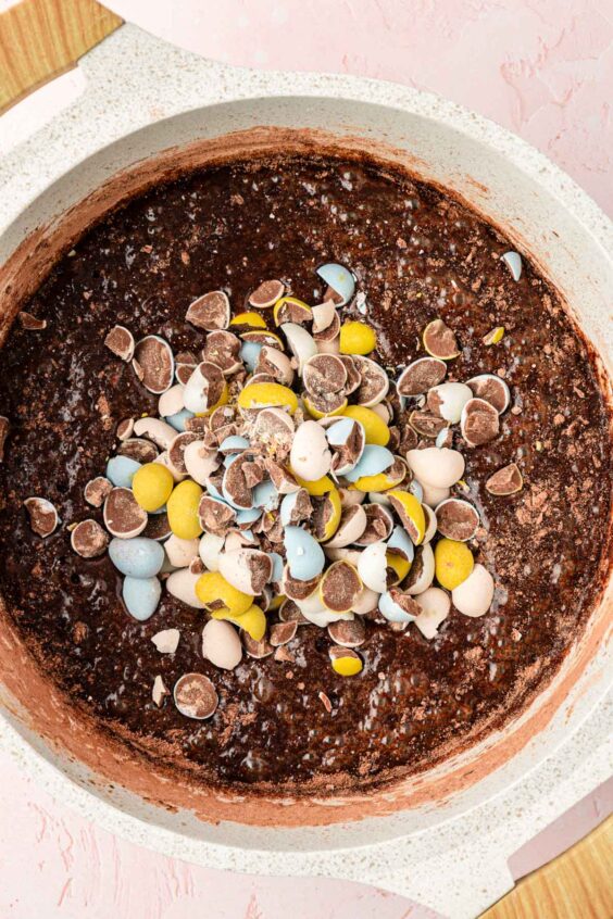 Cadbury mini eggs being added to brownie batter.