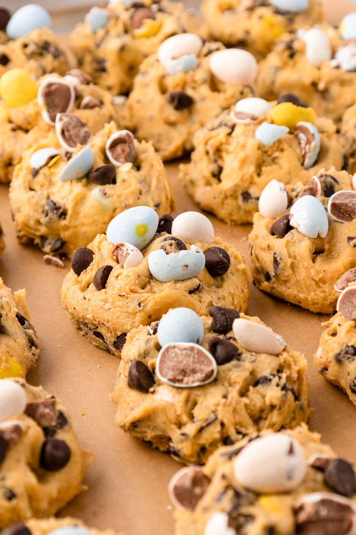 Balls of Cadbury Egg Cookie Dough on a baking sheet.