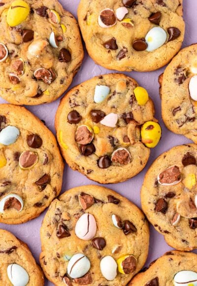 Overhead photo of Cadbury Mini Egg Cookies on a purple surface.