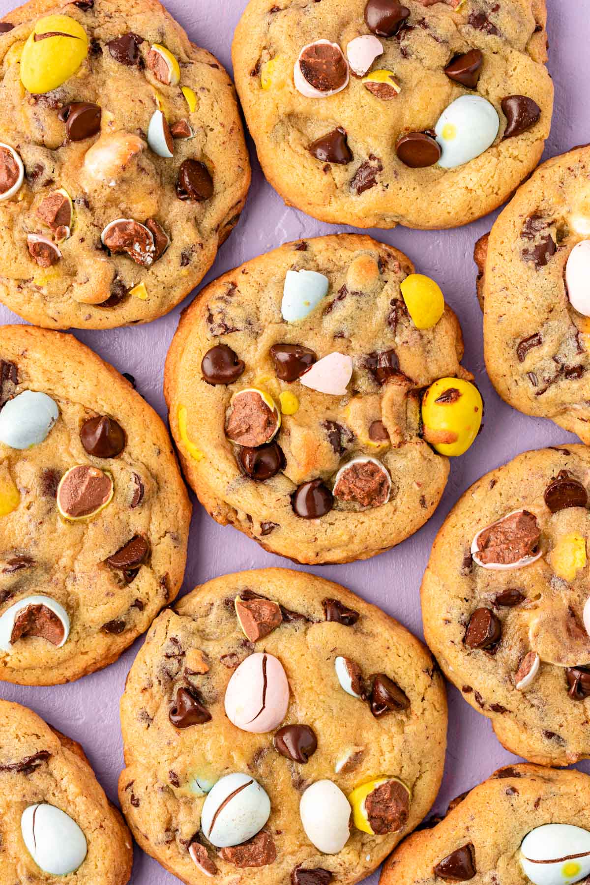 Overhead photo of Cadbury Mini Egg Cookies on a purple surface.