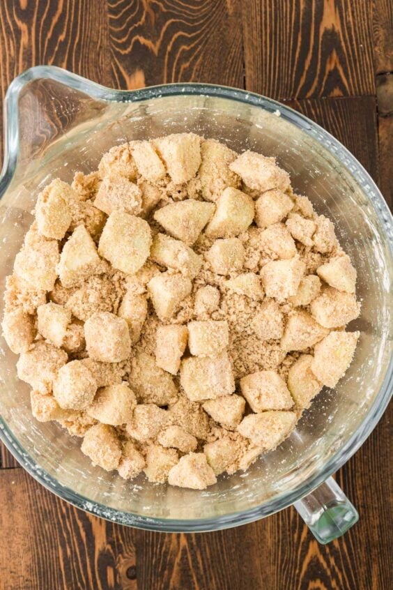 Chopped apples coated in cake mix in a bowl.