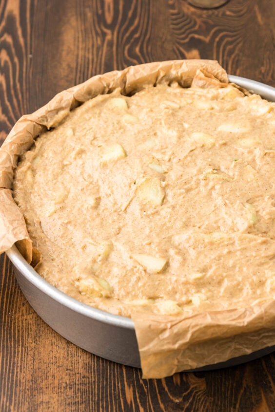 Apple cake batter in a round pan.