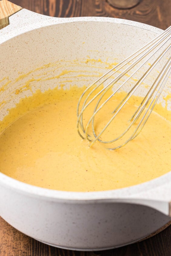 Vanilla custard being whisked in a pot.