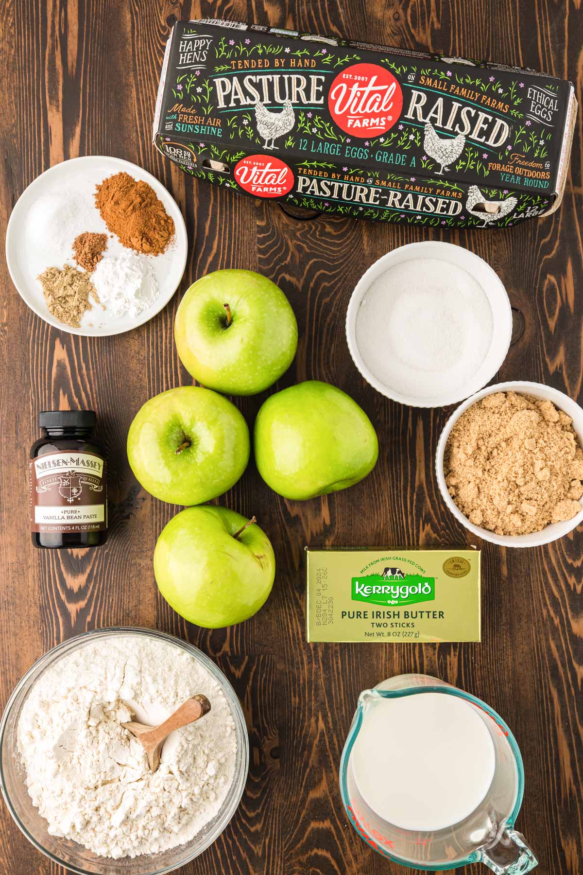 Ingredients to make apple cake on a wooden table.