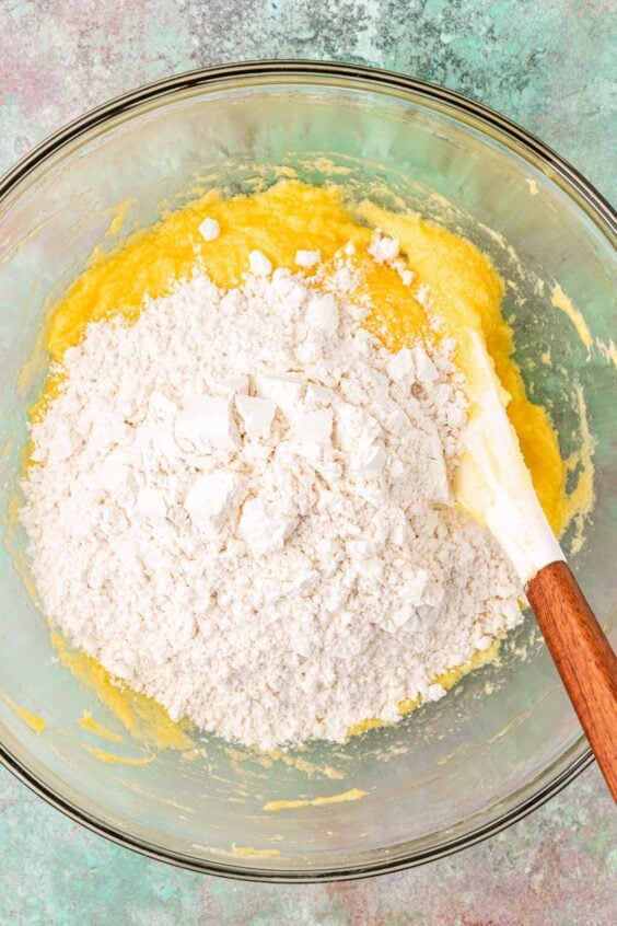 Dry ingredients being added to wet ingredients in a mixing bowl.