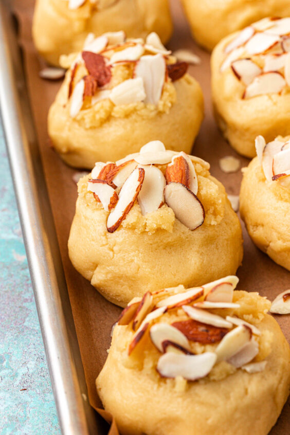 Almond slices pressed into the top of cookie dough balls.
