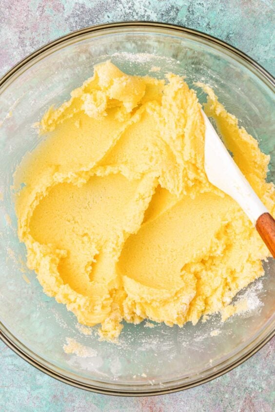 Butter and sugar creamed together in a glass mixing bowl.